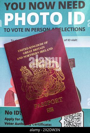 Britischer Reisepass mit einem Faltblatt, aus dem hervorgeht, dass die Wähler in England bei einigen Wahlen einen Lichtbildausweis vorlegen müssen, um an Wahllokalen wählen zu können. UK Stockfoto