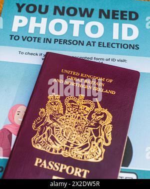 Britischer Reisepass mit einem Faltblatt, aus dem hervorgeht, dass die Wähler in England bei einigen Wahlen einen Lichtbildausweis vorlegen müssen, um an Wahllokalen wählen zu können. UK Stockfoto