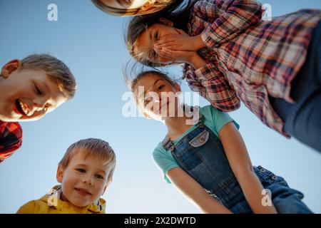 Porträt von überraschten Klassenkameraden, Studenten während des Biologieunterrichts, die auf etwas Interessantes im Gras hinunterschauen. Erfahren Sie mehr über Stockfoto