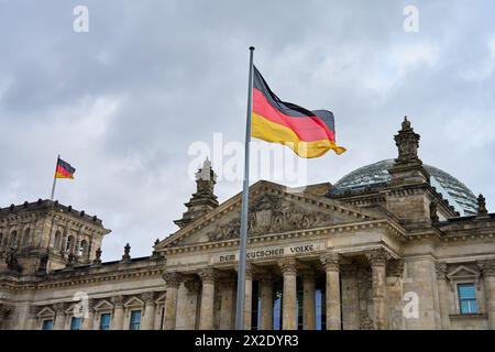 Bundesflagge fliegt im Wind auf dem Reichstagsgebäude in Berlin. Historisches architektonisches Wahrzeichen in Deutschland. Sehenswürdigkeiten für Touristen Stockfoto