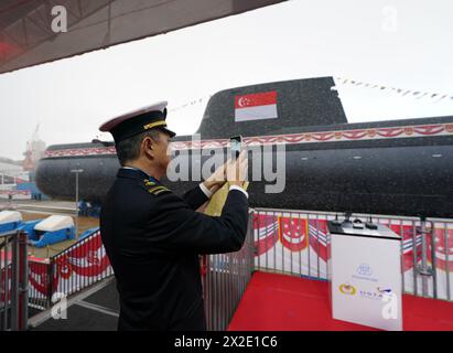 Kiel, Deutschland. April 2024. Ein Mitglied der Marine aus Singapur fotografiert ein U-Boot des Typs 218SG in der Werft der Howaldtswerke-Deutsche Werft AG. Dieses U-Boot ist das letzte von vier U-Booten des Typs 218SG, die ThyssenKrupp Marine Systems für die Republik Singapur gebaut hat. Quelle: Marcus Brandt/dpa/Alamy Live News Stockfoto