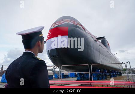 Kiel, Deutschland. April 2024. Ein Mitglied der Singapore Navy steht vor einem U-Boot des Typs 218SG auf der Werft der Howaldtswerke-Deutsche Werft AG. Dieses U-Boot ist das letzte von vier U-Booten vom Typ 218SG, die ThyssenKrupp Marine Systems für die Republik Singapur gebaut hat. Quelle: Marcus Brandt/dpa/Alamy Live News Stockfoto