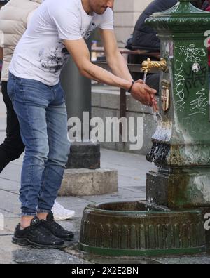 Person tanken mit Wasser am Brunnen auf dem Scala-Platz in Mailand, Italien Stockfoto