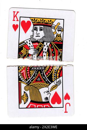 Zerrissene Hälften von Vintage-Spielkarten, die einen König und einen Herzklopfen auf weißem Hintergrund zeigen. Stockfoto