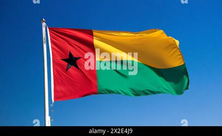 Die Fahne von Guinea-Bissau, flattert im Wind, isoliert, gegen den blauen Himmel Stockfoto