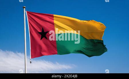 Die Fahne von Guinea-Bissau, flattert im Wind, isoliert, gegen den blauen Himmel Stockfoto