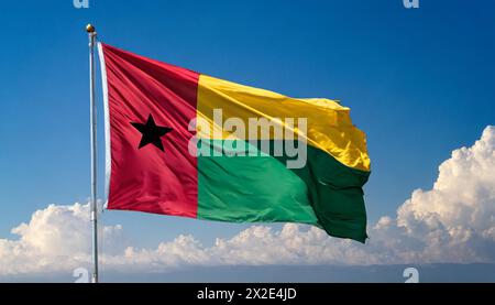 Die Fahne von Guinea-Bissau, flattert im Wind, isoliert, gegen den blauen Himmel Stockfoto