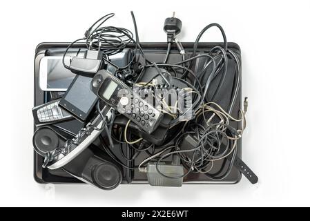 Recycelbare Elektronikschrott, isoliert auf weißem Hintergrund. Ein Haufen gemischter Elektroschrott, alte kaputte Computerteile, Laptops, Handys Stockfoto