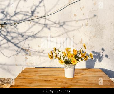 Ein Strauß Wildblumen in einer Vase auf einem Holztisch Stockfoto