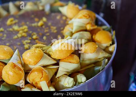 Gedämpfter Khanom Tarn oder kleiner Palmkuchen, mit Palmblatt in Topf gewickelt Stockfoto