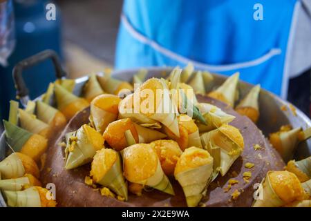 Gedämpfter Khanom Tarn oder kleiner Palmkuchen, mit Palmblatt in Topf gewickelt Stockfoto