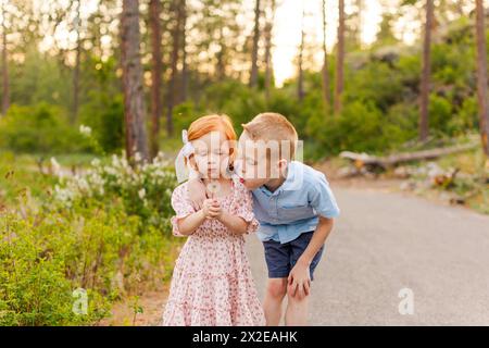 Junge und Mädchen blasen zusammen auf Löwenzahn Stockfoto