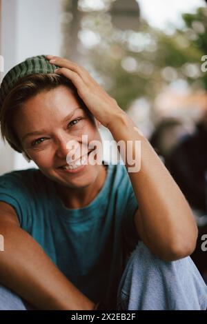 Glückliche lachende Frau, die ihre Kappe über die Augen zieht. Narr. Stockfoto