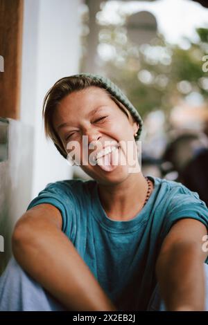 Nahporträt einer glücklichen Frau mit herausstehender Zunge Stockfoto