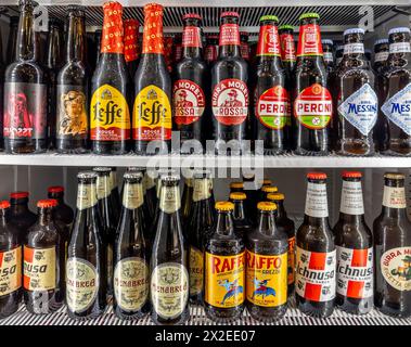 Italien - 04. april 2024: Bier in Glasflaschen verschiedener Typen und Marken in Kühltheken. Italienische, sizilianische und sardische Biere und Leffe-Biene Stockfoto