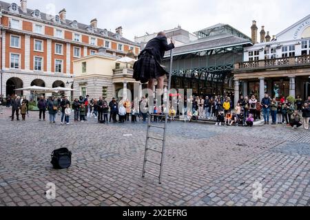 Straßenkünstler mit hoher Leiter unterhält die versammelte Menge mit seinem Auftritt am 9. April 2024 in London, Großbritannien. Stockfoto