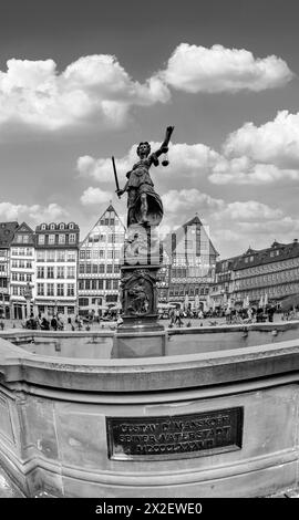 Frankfurt, Deutschland - 10. April 2024: Statue der Justizfrau mit dem alten Brunnen am Frankfurter römerplatz. Stockfoto