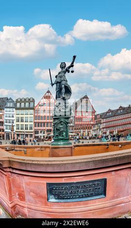 Frankfurt, Deutschland - 10. April 2024: Statue der Justizfrau mit dem alten Brunnen am Frankfurter römerplatz. Stockfoto