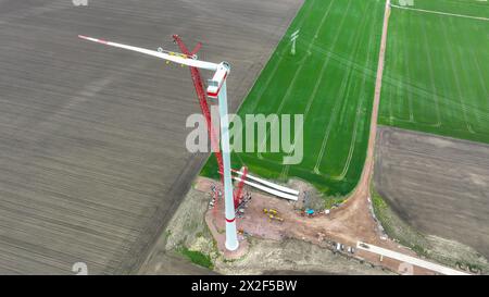 22. April 2024, Sachsen-Anhalt, Bad Lauchstädt: Die letzten Rotorblätter einer Windkraftanlage werden mit einem Kran im Energiepark Bad Lauchstädt installiert (Luftsicht mit Drohne). Der Energiepark Bad Lauchstädt in Mitteldeutschland ist derzeit das Pionierprojekt für Wasserstoff in Deutschland. In diesem Innovationsprojekt wird die Herstellung von grünem Wasserstoff aus Windkraft sowie dessen Speicherung, Transport, Vermarktung und Nutzung erstmals in Mitteldeutschland industriell getestet. Foto: Heiko Rebsch/dpa Stockfoto