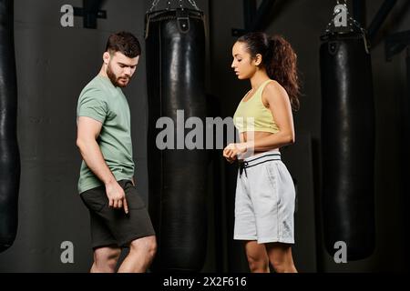 Ein männlicher Trainer unterrichtet einer Frau in einem Fitnessstudio Selbstverteidigungstechniken. Stockfoto