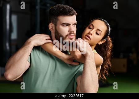 Eine Frau, die Selbstverteidigung mit einem Mann im Fitnessstudio hat. Stockfoto
