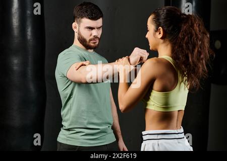 Ein männlicher Trainer bringt einer Frau im Fitnessstudio Techniken zur Selbstverteidigung bei. Stockfoto