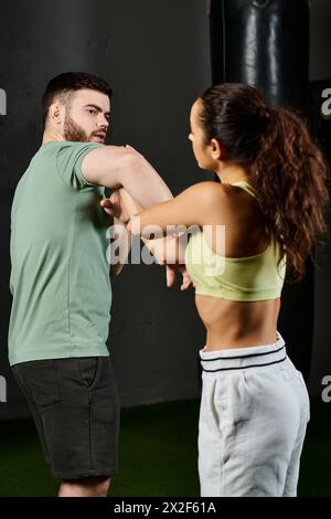 Ein männlicher Trainer bringt einer Frau im Fitnessstudio Techniken zur Selbstverteidigung bei. Stockfoto