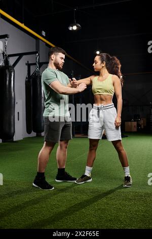 Ein männlicher Trainer bringt einer Frau im Fitnessstudio Techniken zur Selbstverteidigung bei. Stockfoto