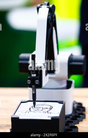 Hannover, Deutschland. April 2024. Ein Roboter zeichnet ein Porträt an einem Stand der Hannover Messe 2024. Kredit: Moritz Frankenberg/dpa/Alamy Live News Stockfoto