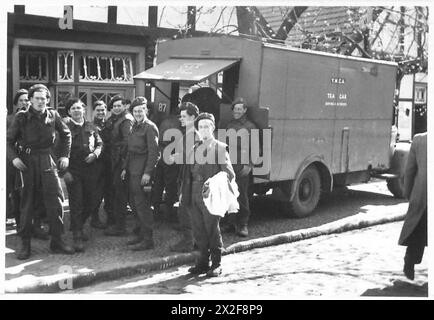 Britische Truppen der 53. Division versammeln sich um einen mobilen YMCA-Van in Westercappel, um den Soldaten während des Zweiten Weltkriegs Erholungs- und Unterstützungsdienste zu bieten Stockfoto