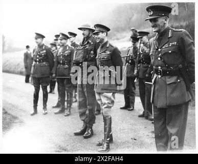 Ein Foto aus dem Zweiten Weltkrieg zeigt König Georg VI., der eine militärische Übung im Southern Command beobachtet. Das Bild fängt den König ein Lächeln ein, während er die Truppen in Aktion sieht, was seine Beteiligung an der militärischen Moral widerspiegelt. Stockfoto
