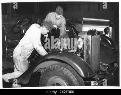 Im R.A.S.C. Depot in Feltham tunen die Mitarbeiter den Motor eines Morris-Trucks, um die Fahrzeugwartung und die logistische Unterstützung der britischen Armee zu veranschaulichen. Stockfoto
