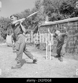 Mitglieder der 6th Airborne Division Signals der British Army spielen am 31. Juli 1944 Cricket in der Normandie, wobei Lance Corporal M. A. Bate während des Spiels spielte. Stockfoto