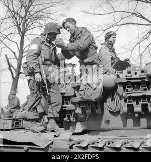 Ein Fallschirmjäger der 17. US-amerikanischen Luftlandedivision erhält am 29. März 1945 ein Licht von einem Churchill-Panzermann der 6. Guards Panzerbrigade in der Nähe von Dorsten. Stockfoto