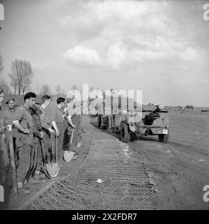 DIE BRITISCHE ARMEE IN NORDWESTEUROPA 1944-45 – Royal Engineer Sappers beobachten, wie 25 pdr-Feldgeschütze in Richtung Waterloo Bridge, einer Bailey-Brücke über den Rhein, am 27. März 1945 abgeschleppt werden Stockfoto