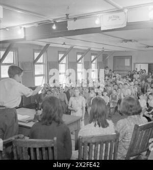 SCHULE FÜR EVAKUIERTE: ALLTAG IN MARCHANT'S HILL CAMP SCHOOL, HINDHEAD, SURREY, ENGLAND, GROSSBRITANNIEN, 1944: Ein Schultreffen in der Marchant's Hill School, Hindhead. Der 14-jährige Vic Randall (links) leitet die Sitzung. Das Treffen findet in einer der großen Holzhütten statt, die als Unterkunft und Klassenzimmer in der Schule dienen Stockfoto