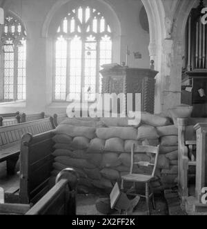 US BATTLE TRAINING AREA, DEVON, ENGLAND, Großbritannien, SEPTEMBER 1944 – Ein Stapel Sandsäcke schützt die Kanzel der Slapton Church in Devon. Diese Taschen wurden installiert, um das Kircheninnere während der Trainingsübungen zu schützen, die von der US-Armee in Vorbereitung auf die Landungen am D-Day durchgeführt wurden. Die Kirche wurde durch den Schiffsangriff, der im Rahmen dieser Ausbildung stattfand, schwer beschädigt, und einige dieser Schäden sind an der Säule hinter der Kanzel zu sehen Stockfoto