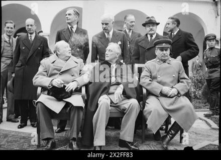 DIE KONFERENZ VON YALTA, FEBRUAR 1945 - die "Großen drei", Winston Churchill, Präsident Roosevelt und Marschall Stalin, sitzen während der Konferenz von Yalta vor dem Livadia-Palast für ein Gruppenfoto. Hinter ihnen, von links nach rechts, stehen: Ein unbekannter Mann; Lord Leathers, der britische Kriegsminister für Transport; Rt Hon Anthony Eden, der britische Außenminister; Edward Stettinius, der amerikanische Außenminister; Rt Hon Sir Alexander Cadogan, der Ständige britische Staatssekretär für auswärtige Angelegenheiten; Herr Vjatscheslaw Molotow, sowjetischer Kommissar für auswärtige Angelegenheiten, und Herr Averell Harrima Stockfoto