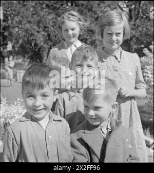 STADTVERWALTUNG IN Einer LANDSTADT: ALLTAG IN WOTTON-UNDER-EDGE, GLOUCESTERSHIRE, ENGLAND, Großbritannien, 1944 - Eine Gruppe lächelnder Kinder posiert bei Sonnenschein für die Kamera in „Dryleaze“, einem Kinderheim, das vom Gloucestershire County Council in Wotton-under-Edge betrieben wird. Der ursprüngliche Titel besagt, dass es vom Ausschuss für öffentliche Unterstützung des Rates „auf „heimeligen“ Zeilen geführt wird und dass „seine Kinder an allen normalen Aktivitäten des normalen Stadtlebens teilnehmen und trainiert werden, ihren Lebensunterhalt zu verdienen, wenn sie die Schule verlassen. Die Mädchen bleiben länger dran als die Jungs. Sehen Sie es als ihr Zuhause, com Stockfoto