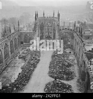 COVENTRY, ENGLAND, FRÜHJAHR 1944 - dieses Luftbild mit Blick in die hohlen, dachlosen Hülle der Kathedrale von Coventry wurde vom Westturm aufgenommen und zeigt, wie ein Weg durch die Schutt und Trümmer entlang des Mittelschiffs des Gebäudes gerettet wurde. Ein Kreuz aus verkohlten Dachbalken ist nur an der Stelle des Hochaltars zu sehen Stockfoto