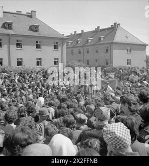 DIE BEFREIUNG DES KONZENTRATIONSLAGERS BERGEN-BELSEN, MAI 1945 – jüdische Lagerinsassen halten einen Freiluftdienst ab, um das Jüdische Sommerfest des Thanksgiving zu feiern. Der Dienst wurde von Rev Leslie H Hardman, Senior Jewish Chaplan der britischen 2. Armee, und ehemaligen Lagerhäftlingen, Rabbiner H Helfgott aus Jugoslowien und Rabbiner B Goldfinger aus Polen geführt. Hinter dem Freiluftaltar halten Internierte einen Wandteppich, der ursprünglich im Besitz der jüdischen Gemeinde Siziliens war, der bis zur Befreiung in das Lager gebracht und von Internierten versteckt wurde. British Army, Royal Army Chaplains' Department Stockfoto