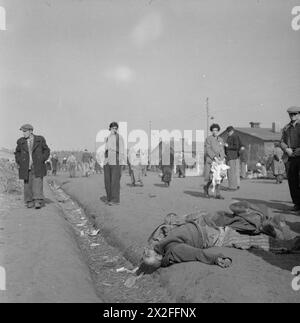 Im April 1945 wurden Häftlinge aus Bergen-Belsen gezeigt, die an der Leiche eines Gefangenen vorbeikamen, der zusammenbrach und an Hunger starb, was die extremen Bedingungen und die weit verbreitete Unterernährung im Lager widerspiegelte. Stockfoto