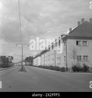 DIE BEFREIUNG DES KONZENTRATIONSLAGERS BERGEN-BELSEN, APRIL 1945 – die Straße, die zum Krankenhaus in Lager Nr. 2 führt, wurde von britischen Krankenwagen benutzt, um Häftlinge aus dem krankheitsgeplagten und überfüllten Lager Nr. 1 in Belsen zu evakuieren. Die deutsche Wehrmachtskaserne und das Militärkrankenhaus in Hohne wurden kommandiert, um Lager Nr. 2 zu schaffen. Bei der Ankunft wurde deutsches medizinisches Personal zur Versorgung der Patienten eingezogen Stockfoto