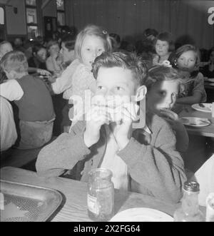 SCHULE FÜR EVAKUIERTE: ALLTAG IN MARCHANT'S HILL CAMP SCHOOL, HINDHEAD, SURREY, ENGLAND, GROSSBRITANNIEN, 1944: Reg Phillips (13 Jahre alt) aus East Ham schlängelt sich im Speisesaal der Marchant's Hill School in Hindhead in einem großen Stück Brot und Marmelade. Laut der Originalüberschrift ist Regs Vater in der Merchant Navy Stockfoto