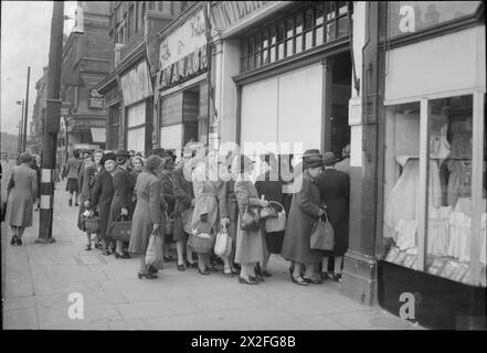 GROSSBRITANNIEN WARTET AUF ESSEN: RATIONIERUNG UND LEBENSMITTELKNAPPHEIT IN KRIEGSZEITEN, LONDON, ENGLAND, Großbritannien, 1945 - Eine Schlange von Frauen, die darauf warten, Kuchen von der Bäckerin und Konditorin Williamson zu kaufen, hält es weit aus dem Geschäft und entlang der Wood Green High Road, London Stockfoto