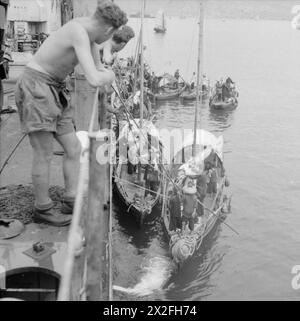 DIE BRITISCHE WIEDERBESETZUNG HONGKONGS 1945: Chinesische Sampane kommen neben dem Landing Ship Tank LST 304 in den Hafen von Hongkong. LST 304 segelte als Teil des ersten Konvois nach Hongkong nach der Kapitulation Japans Stockfoto