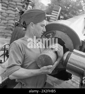 Im Jahr 1942 lädt Gunner Robert Rideout von der New foundland Heavy Artillery Battery in England während des Artillerietrainings eine 100 kg schwere Übungsschale in die Artillerie. Stockfoto