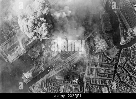 KÖNIGLICHE LUFTWAFFE: ITALIEN, BALKAN UND SÜDOSTEUROPA, 1942-1945. - Operation BOWLER: Angriff auf die Achsenschifffahrt im Hafen von Venedig. Der Rauch steigt aus den Schiffsanlagen und Hafenanlagen im Hafen von Venedig, Italien, während eines Angriffs von North American Mustangs und Curtiss Kittyhawks der No. 239 Wing RAF, Desert Air Force. Operation BOWLER war der einzige zugelassene Bombenangriff auf Venedig während des Krieges. Sie wurde von Air Vice-Marshal R M Foster, Air Officer Commanding the Desert Air Force, benannt, der erwartete, dass sie „Bowler-Hut“ (d. h. den Dienst abgewiesen) werden würde, wenn die Stadt selbst leidet Stockfoto