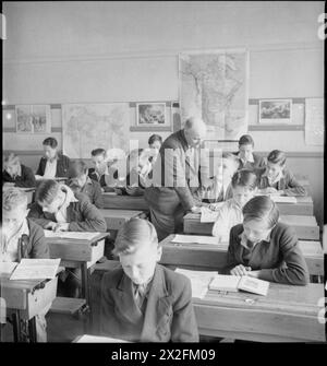 JUNGE BRITEN STUDIEREN AMERIKANISCHE GESCHICHTE: BILDUNG IN KRIEGSZEIT ENGLAND, 1943 - Jungen lernen die Völker Amerikas und ihre Ziele und ideale von ihrem Lehrer Mr. A B Culwell während einer Lektion an der Albany Senior School in Enfield kennen. Laut der Originalüberschrift war Mr. Culwell einst Schulmeister der Royal Navy und besuchte viele Häfen in den Vereinigten Staaten Stockfoto