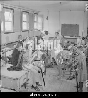 LERNEN DURCH SCHAUSPIELEREI: AUSBILDUNG DURCH THEATER FÜR EVAKUIERTE IN Einer „CAMP SCHOOL“, MARCHANT's HILL, HINDHEAD, SURREY, 1943 – Kinder, die von East Ham zur Marchant's Hill School in Hindhead, Surrey evakuiert wurden, veredelten ihr Make-up und ihre Kostüme 10 Minuten vor Beginn des Stücks, das sie auflegten. Jedes Kind in der Schule hat auf irgendeine Weise zur Leistung beigetragen. Das Klassenzimmer, das als Umkleidezimmer genutzt wird, wird normalerweise von älteren Mädchen für Wäsche und Schneiderei genutzt Stockfoto